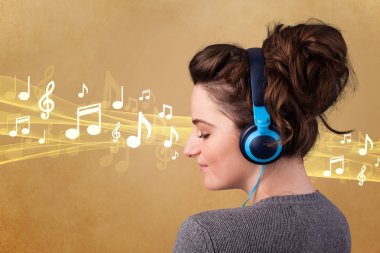 Kulaklıklı genç bir kadın müzik dinliyor.