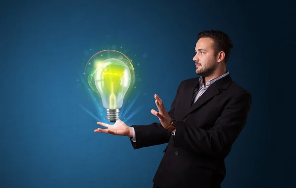 Glowing lightbulb in the hand of a businessman — Stock Photo, Image