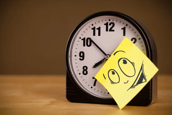 Post-it-Zettel mit Smiley-Zifferblatt auf Uhr geklebt — Stockfoto