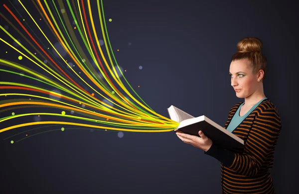 Красивая молодая женщина читает книгу, в то время как цветные линии приближаются — стоковое фото