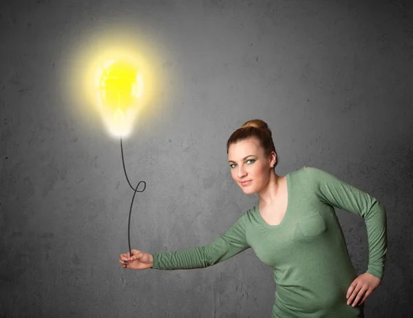 Woman holding a lightbulb balloon — Stock Photo, Image