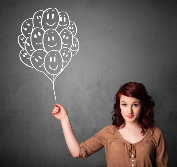 Woman holding a bunch of smiling balloons — Stock Photo, Image