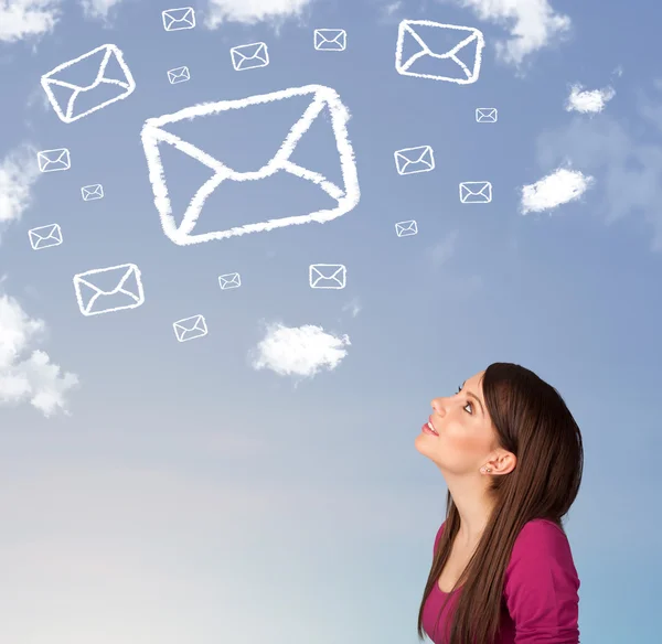 Chica joven mirando el símbolo de correo nubes en el cielo azul —  Fotos de Stock