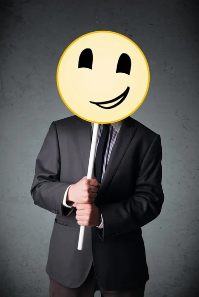 Empresário segurando um emoticon rosto sorridente — Fotografia de Stock