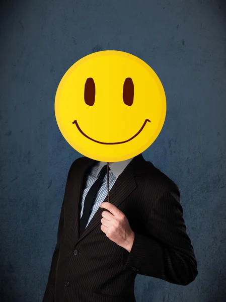 Бізнесмен тримає смайлик емоційне обличчя — стокове фото