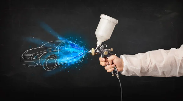 Worker with airbrush gun painting hand drawn car lines — Stock Photo, Image