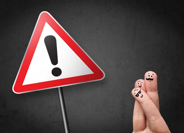 Happy smiley fingers looking at triangle warning sign with excla — Stock Photo, Image