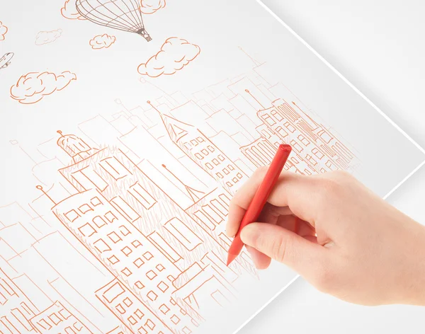 A person drawing sketch of a city with balloons and clouds on a — Stock Photo, Image