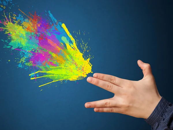 Colorful splashes are coming out of gun shaped hands — Stock Photo, Image