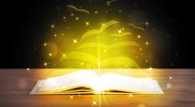 Altından parlak uçan kağıt sayfaları olan açık bir kitap