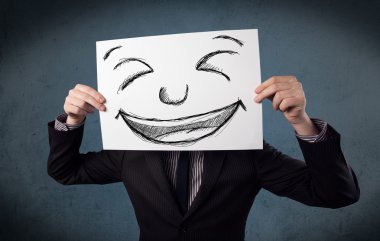 bir kağıt ile gülen yüz onun hea önünde tutan işadamı