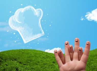 Mutlu gülen yüzlü parmaklar aşçı şapkasının resmine bakıyor.