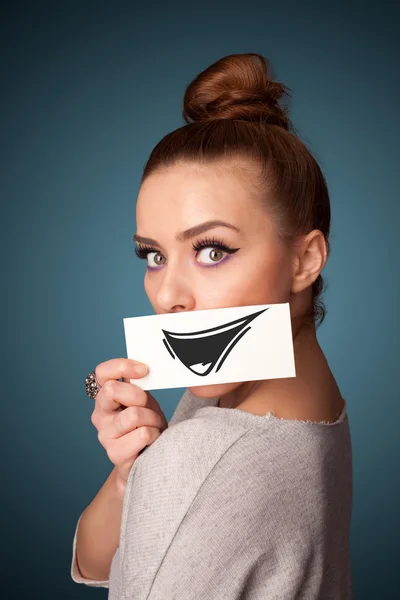 Feliz bonito menina segurando papel com engraçado smiley desenho — Fotografia de Stock