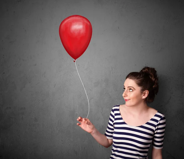 Kvinna som håller en röd ballong — Stockfoto