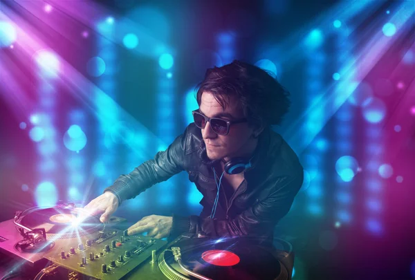 DJ ανάμειξη της μουσικής σε ένα κλαμπ με μπλε και μοβ φώτα — Φωτογραφία Αρχείου