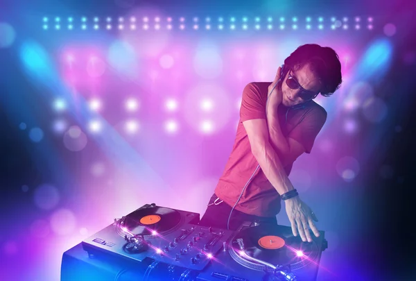 Disc jockey mixen van muziek op de draaitafels op het podium met lichten en — Stockfoto
