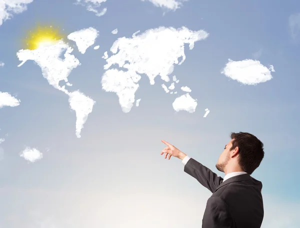 Businessman looking at world clouds and sun on blue sky — Stock Photo, Image
