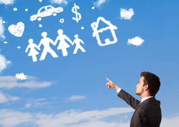 Hombre de negocios soñando despierto con la familia y las nubes del hogar —  Fotos de Stock