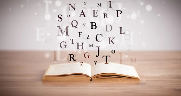 Opened book with flying letters — Stock Photo, Image