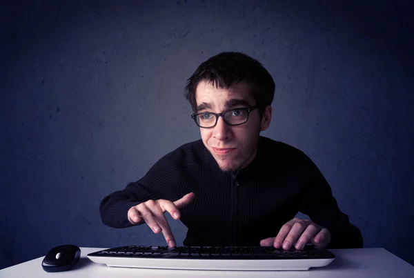 Haker pracujący z klawiaturą na niebieskim tle — Zdjęcie stockowe