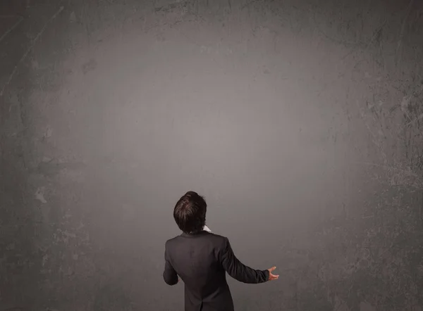 Businessman standing in front of an empty wall — Stock Photo, Image