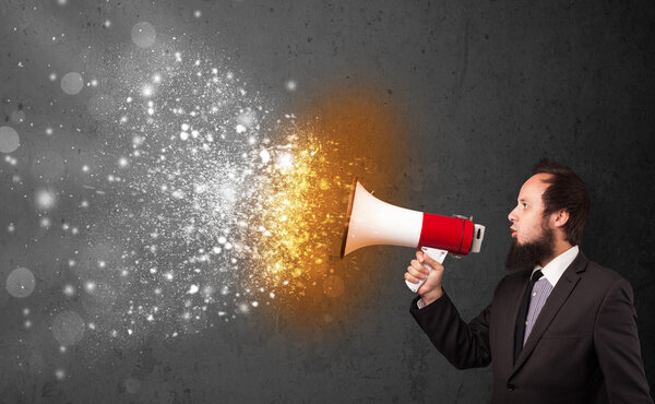 Парень, кричащий в мегафон и пылающие частицы энергии взрываются