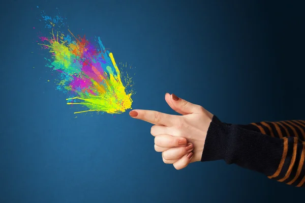 Salpicaduras de colores están saliendo de las manos en forma de pistola —  Fotos de Stock