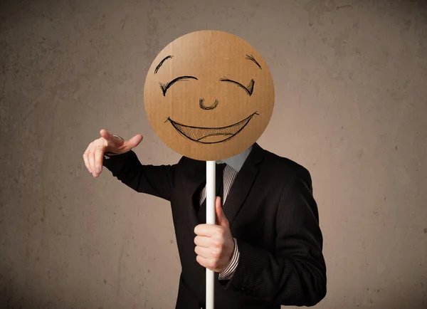 Businessman holding a smiley face board Stock Picture