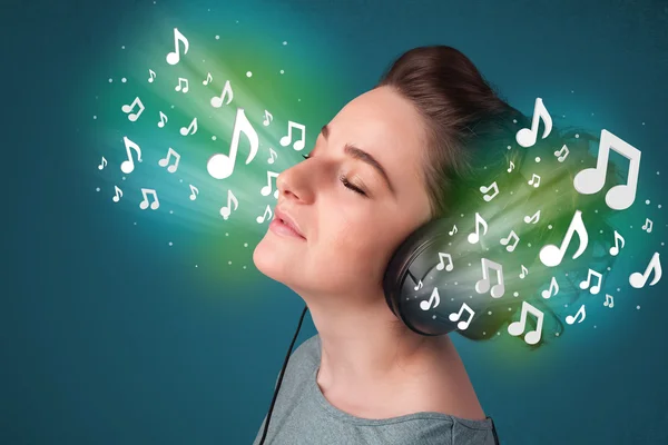 Молода жінка з навушниками слухає музику — стокове фото