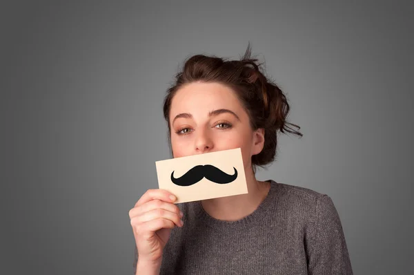 Happy cute girl holding paper with mustache drawing — Stock Photo, Image