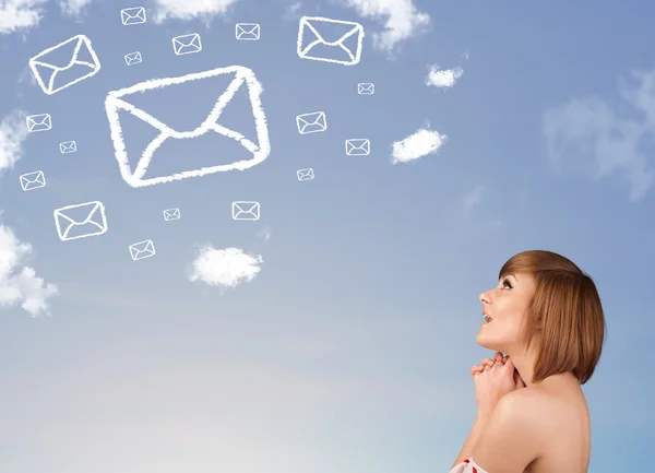 年轻的女孩低头看邮件符号在蓝蓝的天空上的云 — 图库照片