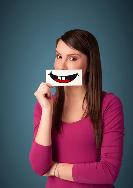 Happy pretty woman holding card with funny smiley — Stock Photo, Image