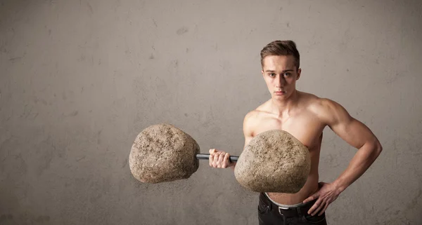 Homem muscular levantando grandes pesos de pedra de rocha — Fotografia de Stock