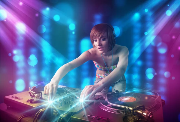 Dj girl mixing music in a club with blue and purple lights — Stock Photo, Image