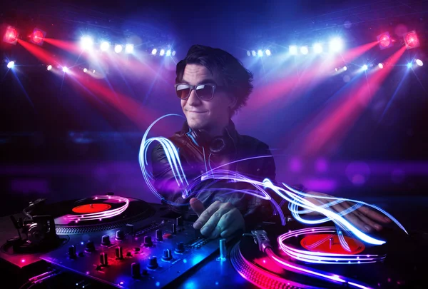 Disc jockey playing music with light beam effects on stage — Stock Photo, Image