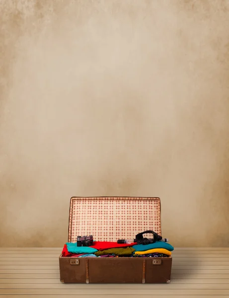 Retro tourist luggage with colorful clothes and copyspace — Stock Photo, Image