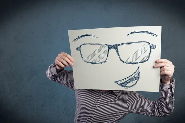 Uomo d'affari in possesso di un foglio con la faccia sorridente di fronte alla sua hea — Foto Stock