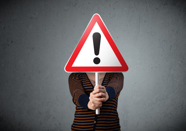 Young woman holding an exclamation road sign