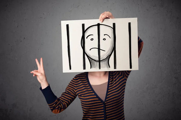 Woman holding a paper with a prisoner behind the bars on it in f — Stock Photo, Image