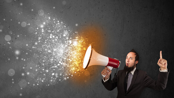 Guy shouting into megaphone and glowing energy particles explode