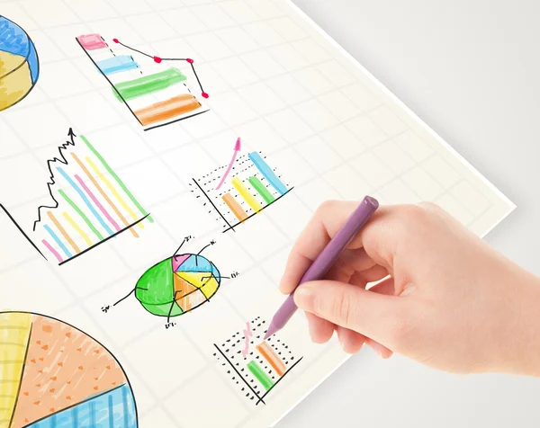 Business person drawing colorful graphs and icons on paper — Stock Photo, Image