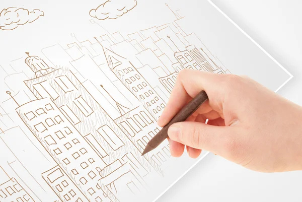 A person drawing sketch of a city with balloons and clouds on a — Stock Photo, Image