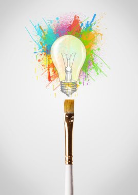 renkli boya sıçraması ve ampul ile fırça yakın çekim