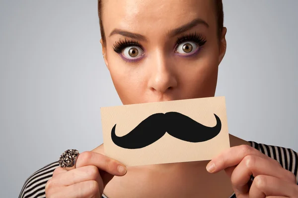 Happy cute girl holding paper with mustache drawing — Stock Photo, Image