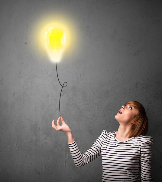 Donna in possesso di un palloncino lampadina — Foto Stock