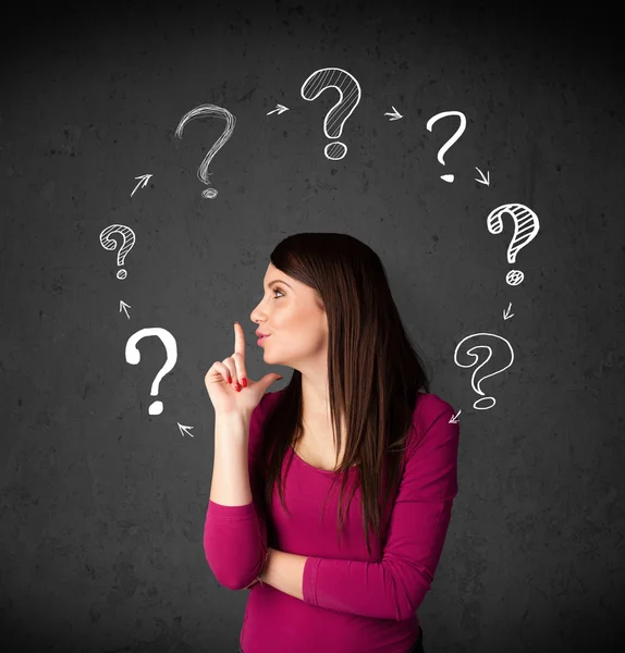 Young woman thinking with question mark circulation around her h — Stock Photo, Image