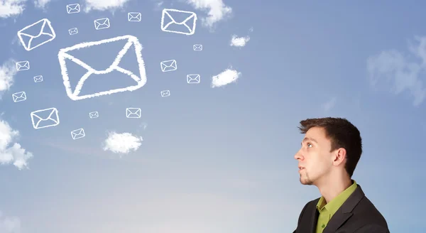 Hombre de negocios mirando el símbolo de correo nubes en el cielo azul —  Fotos de Stock