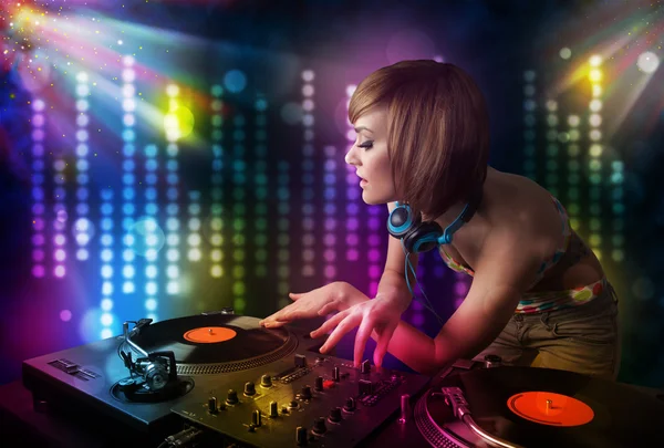 Chica Dj tocando canciones en una discoteca con espectáculo de luz —  Fotos de Stock