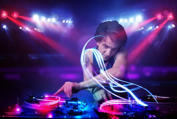 Disc jockey playing music with light beam effects on stage — Stock Photo, Image