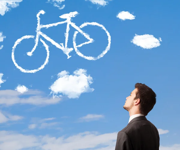 Genç adam mavi gökyüzündeki bisiklet bulutlarına bakıyor. — Stok fotoğraf